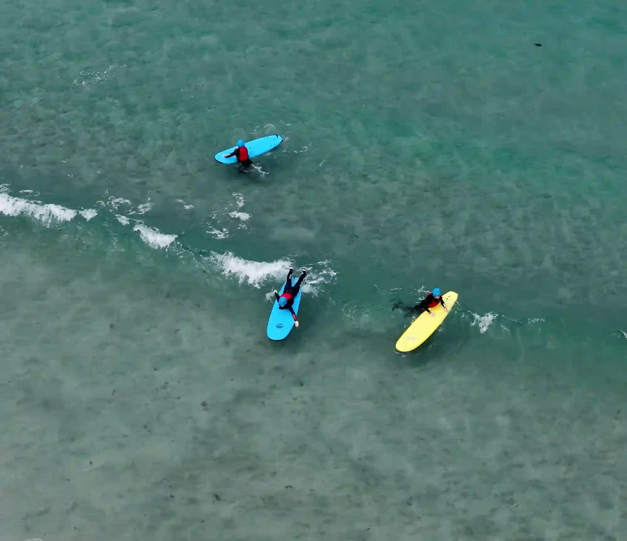 Image of the sea taken from above showing people doing surfing